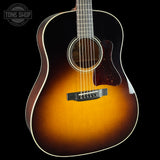 Acoustic guitar with a sunburst finish on a black background, featuring the Tone Shop logo.
