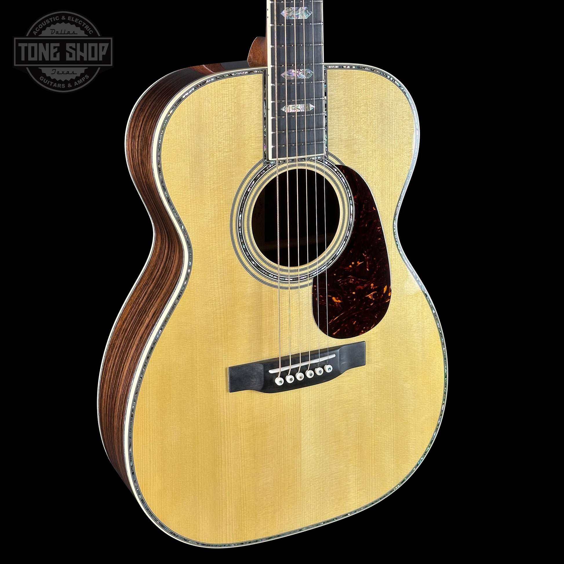 Acoustic guitar with a visible brand logo on a black background