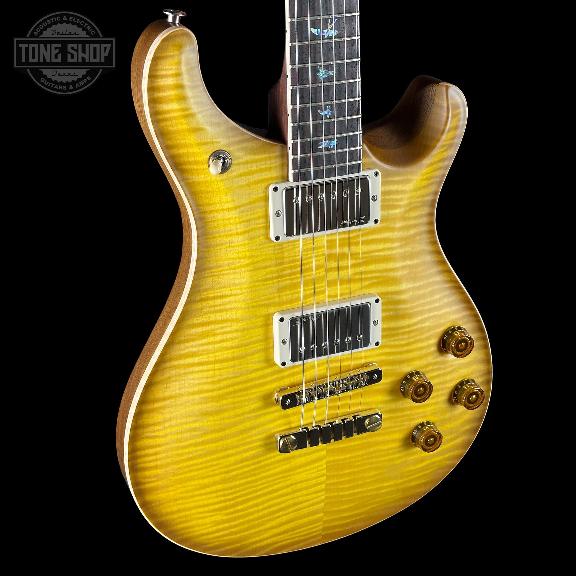 Yellow electric guitar with a 'Tone Shop' logo in the corner