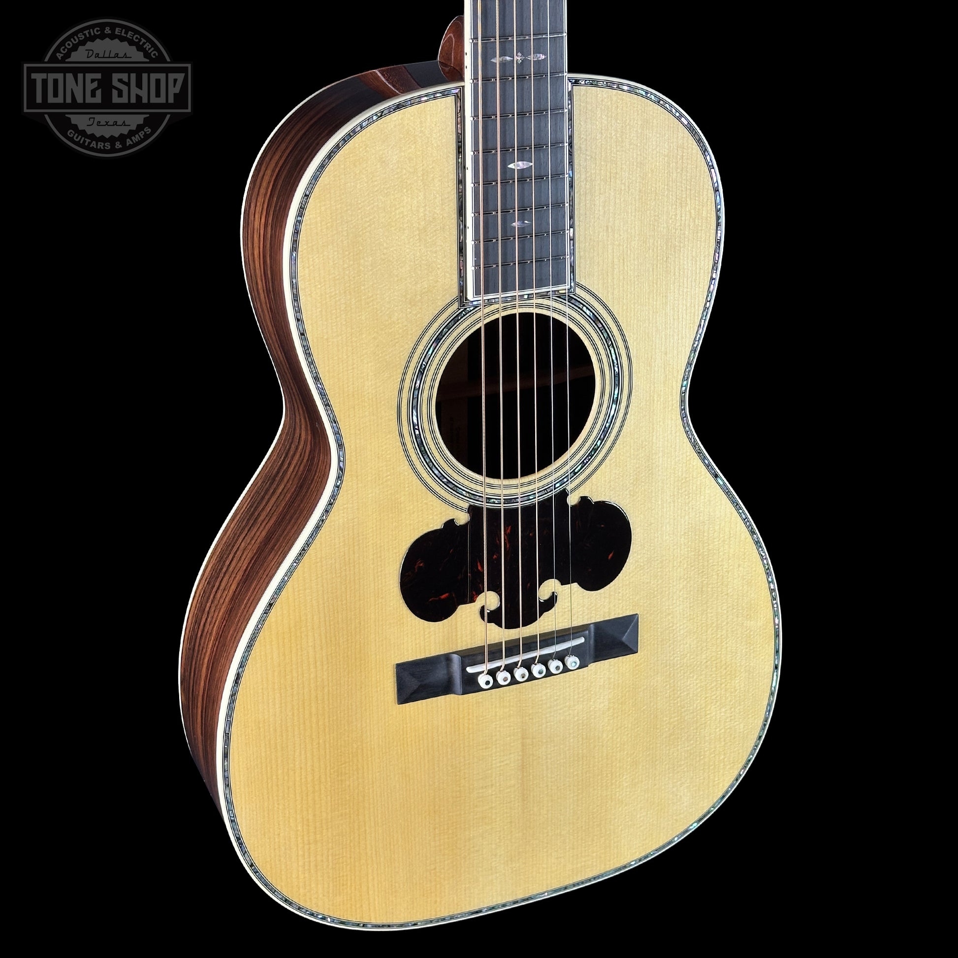 Acoustic guitar with a visible brand logo on a black background