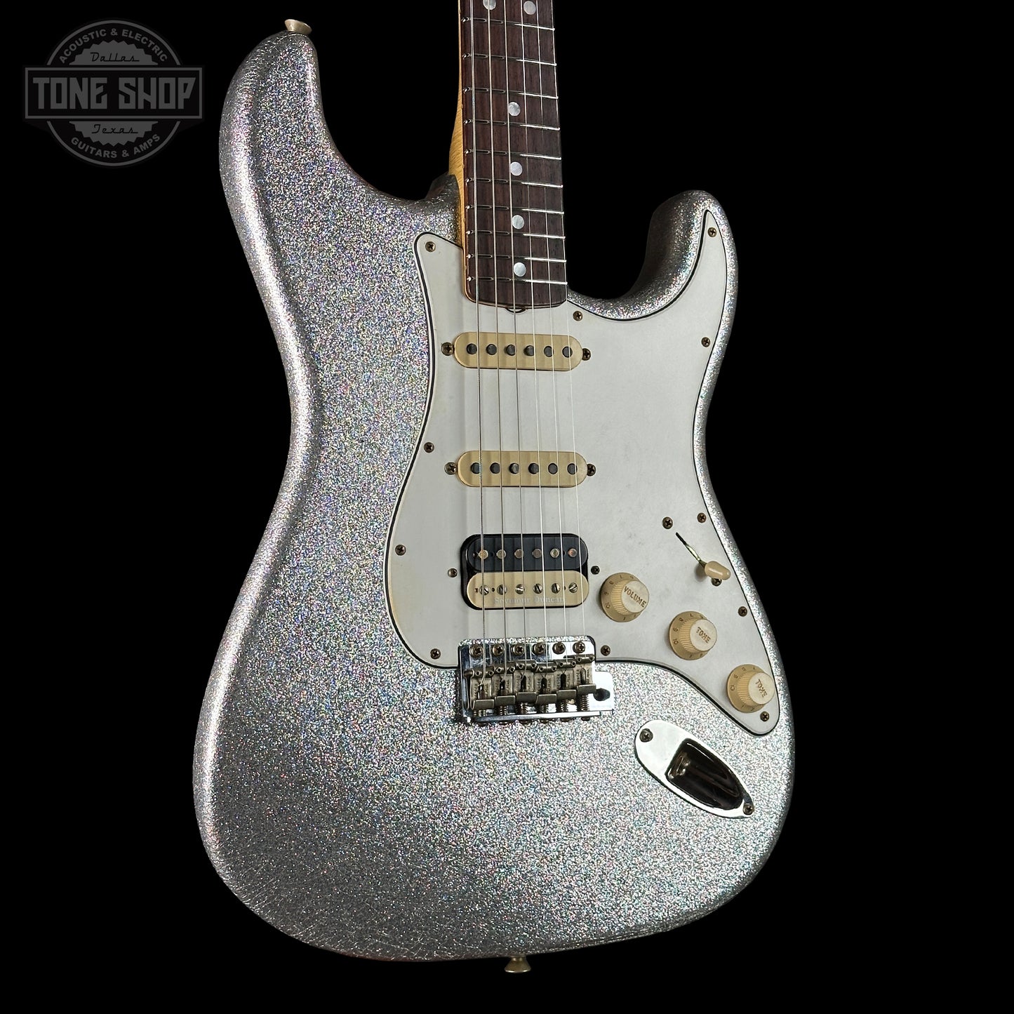Silver glitter electric guitar on a black background with 'Tone Shop' logo.