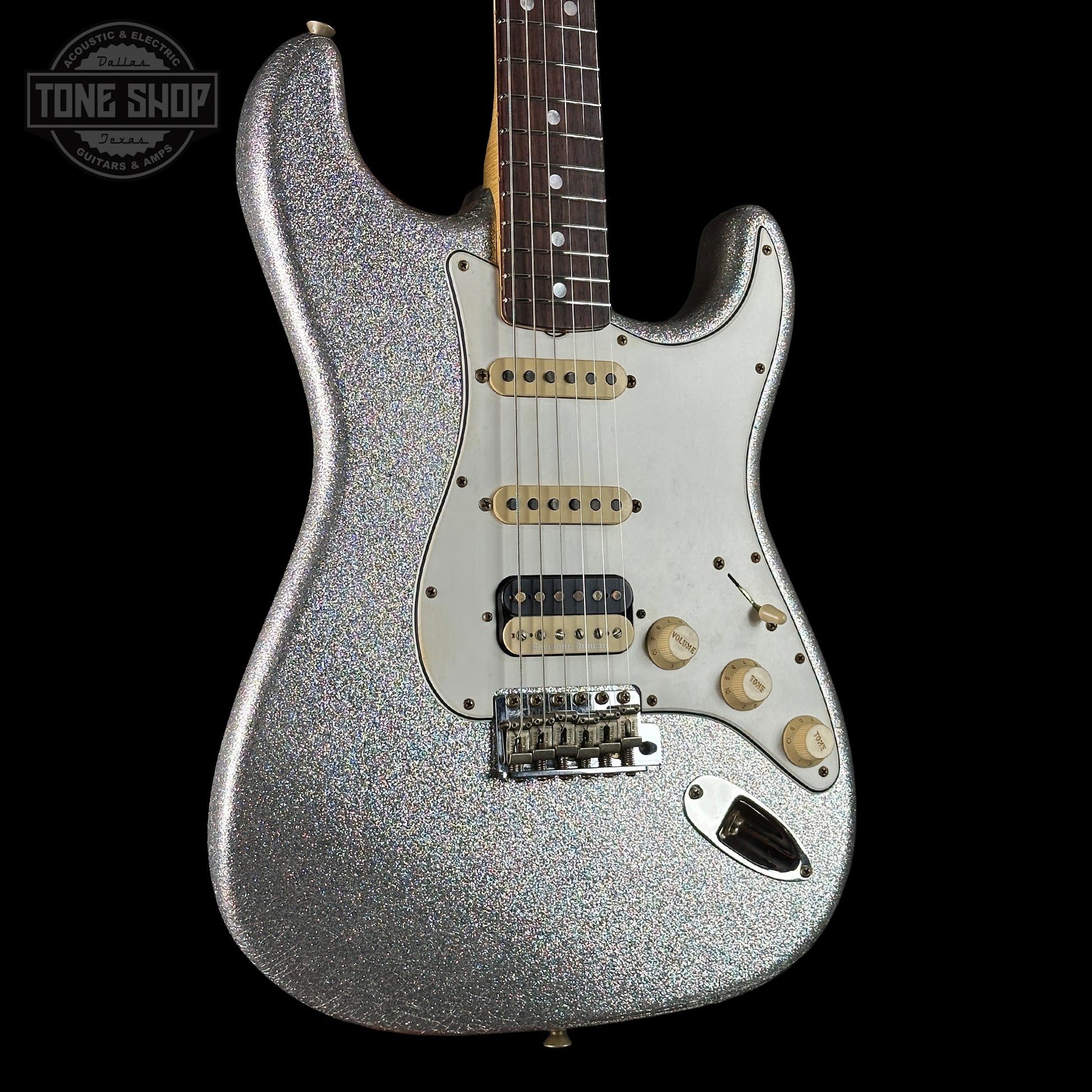 Silver glitter electric guitar on a black background with 'Tone Shop' logo.
