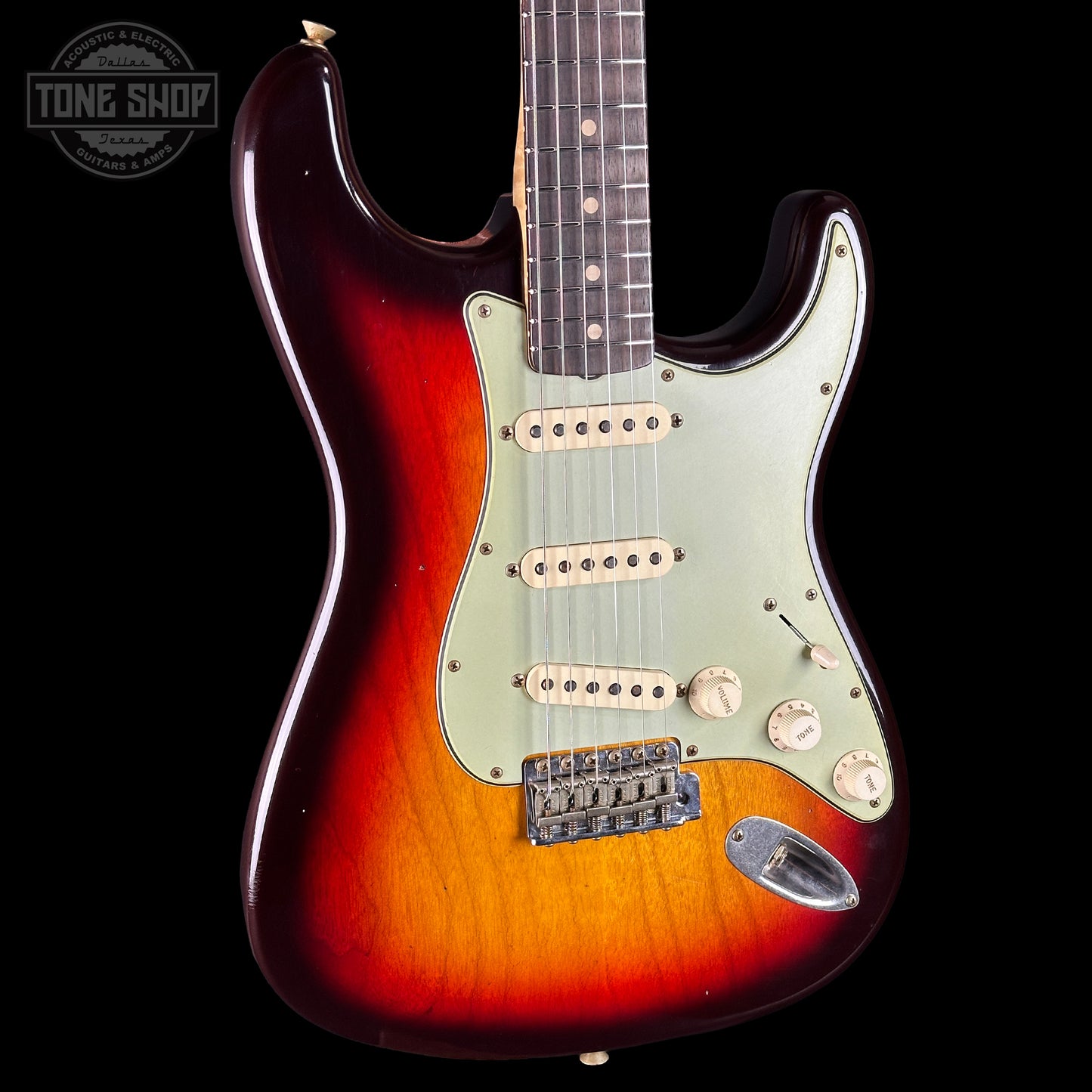 Electric guitar with a sunburst finish on a black background, featuring the Tone Shop logo.
