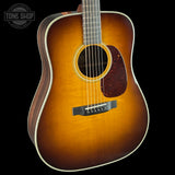 Acoustic guitar with a sunburst finish on a black background, featuring the Tone Shop logo.