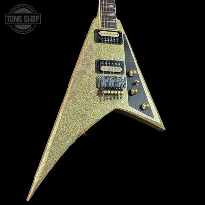 V-shaped electric guitar with a textured finish on a black background, featuring the Tone Shop logo.