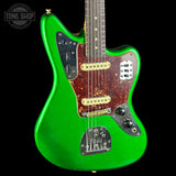 Green electric guitar with a black background