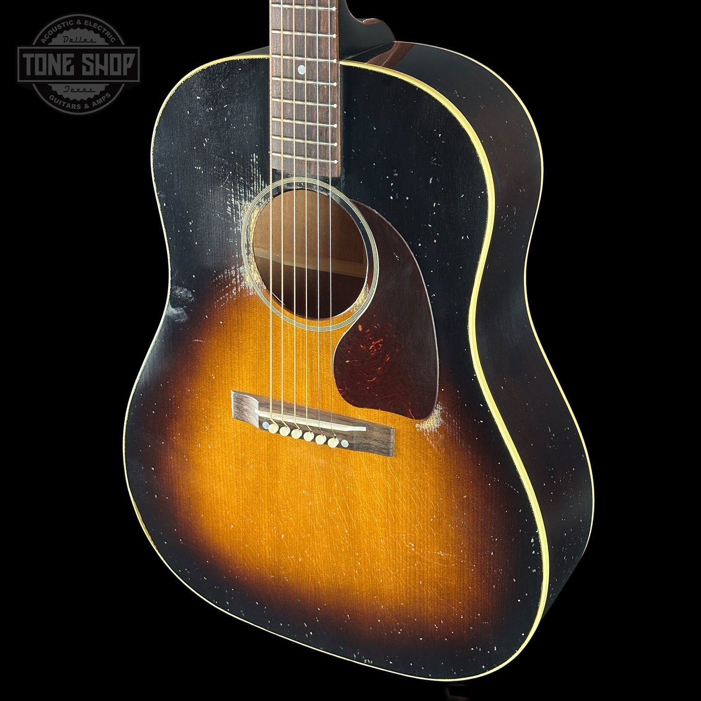 Acoustic guitar with a sunburst finish on a black background, featuring 'Tone Shop' logo.