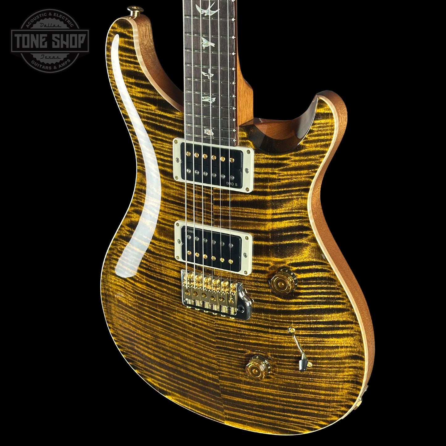 Electric guitar with a wavy wood finish on a black background, featuring the Tone Shop logo.