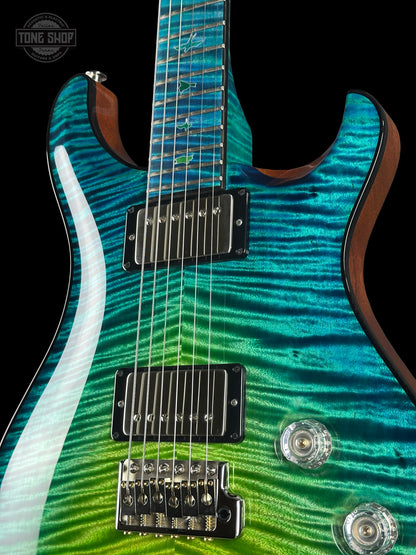 Close-up of a guitar with a wavy green and blue pattern on a black background