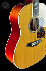 Acoustic guitar with a red and brown finish on a black background