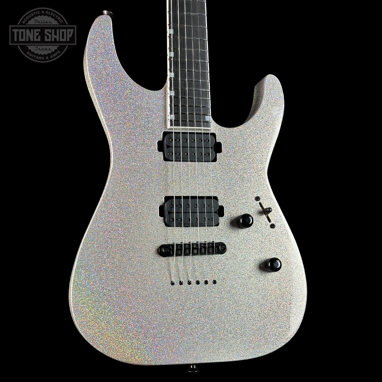 Silver electric guitar with a black pickguard on a black background, featuring 'Tone Shop' branding.