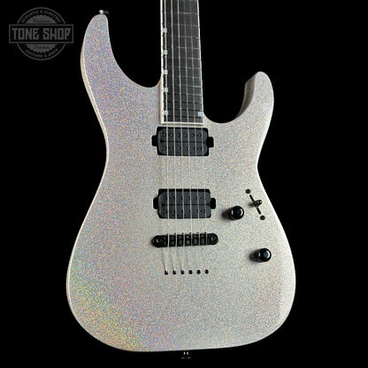 Silver electric guitar with a black pickguard on a black background, featuring 'Tone Shop' branding.