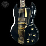 Black electric guitar with gold hardware on a black background, featuring the Gibson logo.
