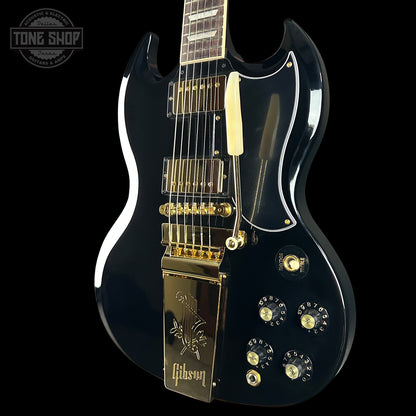 Black electric guitar with gold hardware on a black background, featuring the Gibson logo.