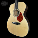 Acoustic guitar with a red soundhole on a black background, featuring the Tone Shop logo.