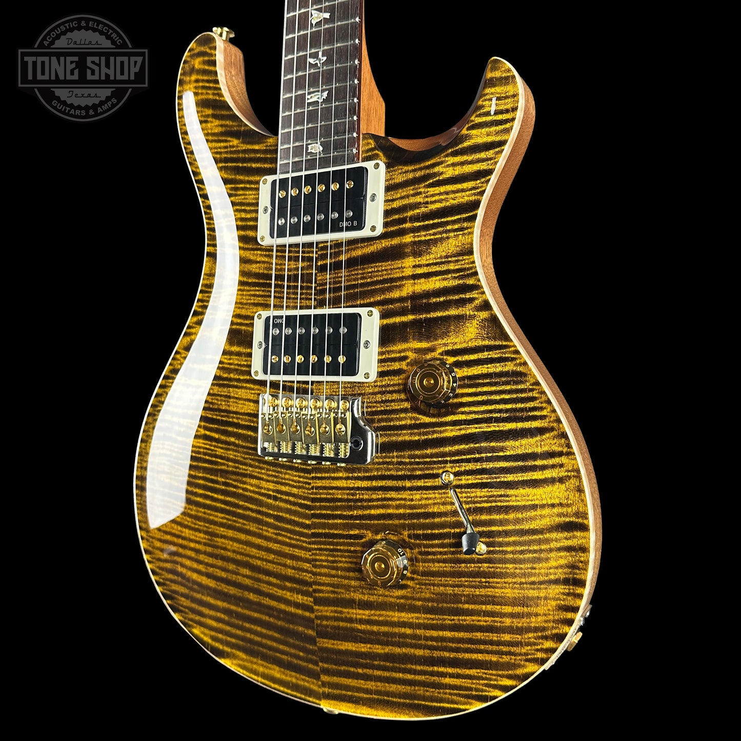 Electric guitar with a sunburst finish on a black background, featuring the Tone Shop logo.