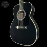 Black acoustic guitar on a black background with 'Tone Shop' logo.