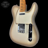 Electric guitar with a blonde finish on a black background, featuring the Tone Shop logo.
