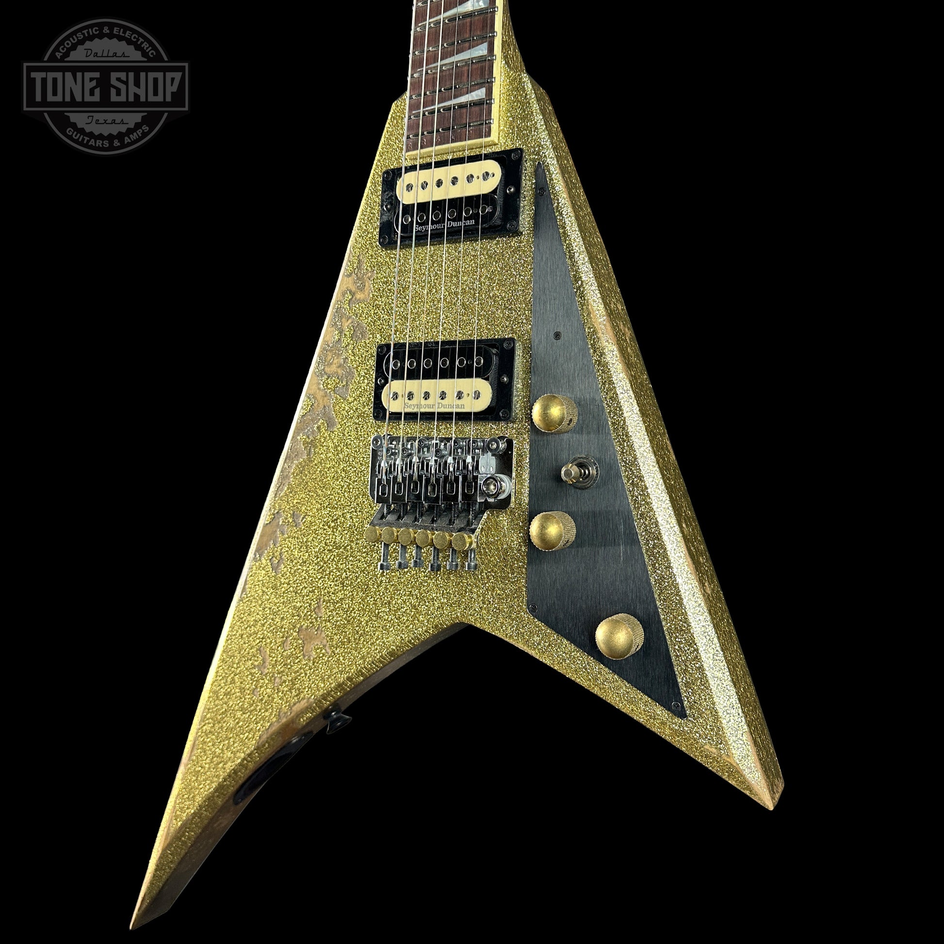 Gold glitter electric guitar on a black background with 'Tone Shop' logo.