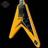 Yellow electric guitar with black pickguard on a black background, featuring 'Tone Shop' logo.