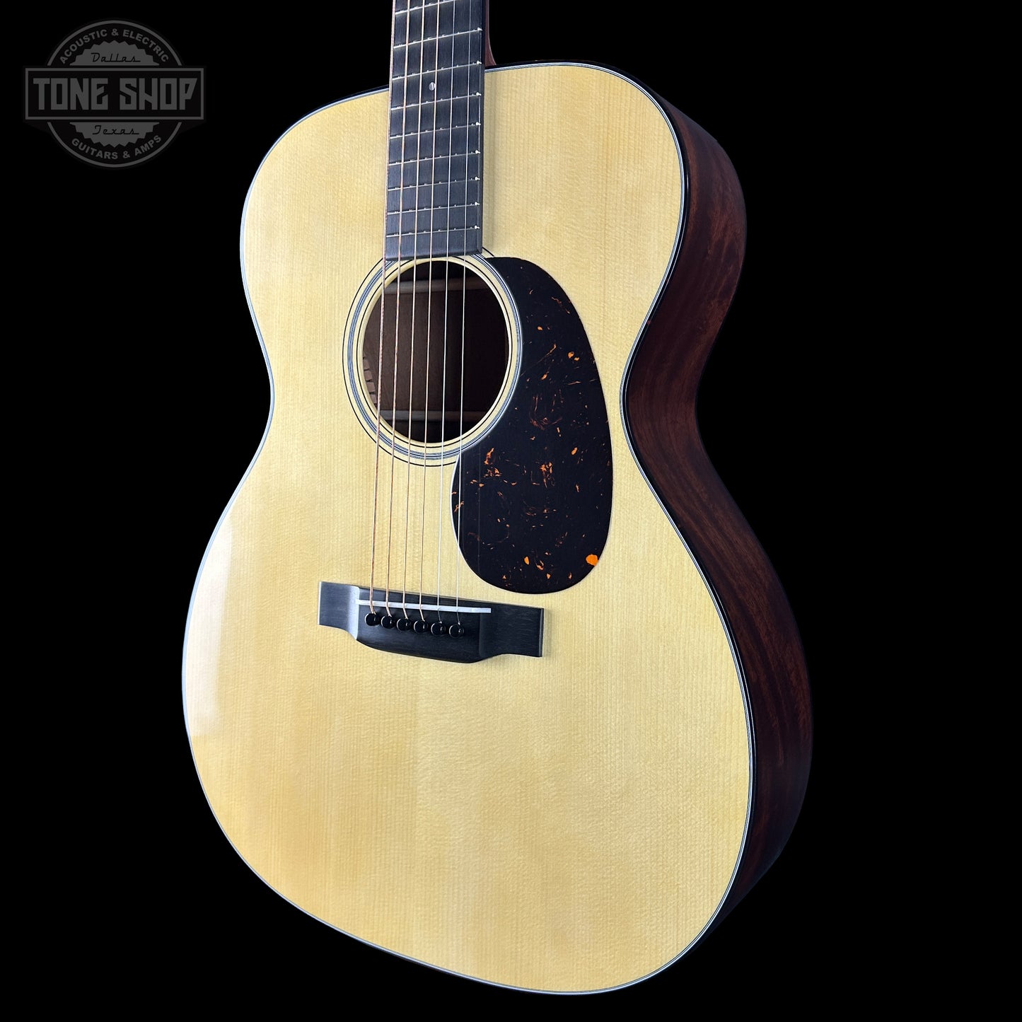 Acoustic guitar with a visible brand logo on a black background