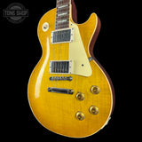 Yellow electric guitar with a 'Tone Shop' logo in the corner