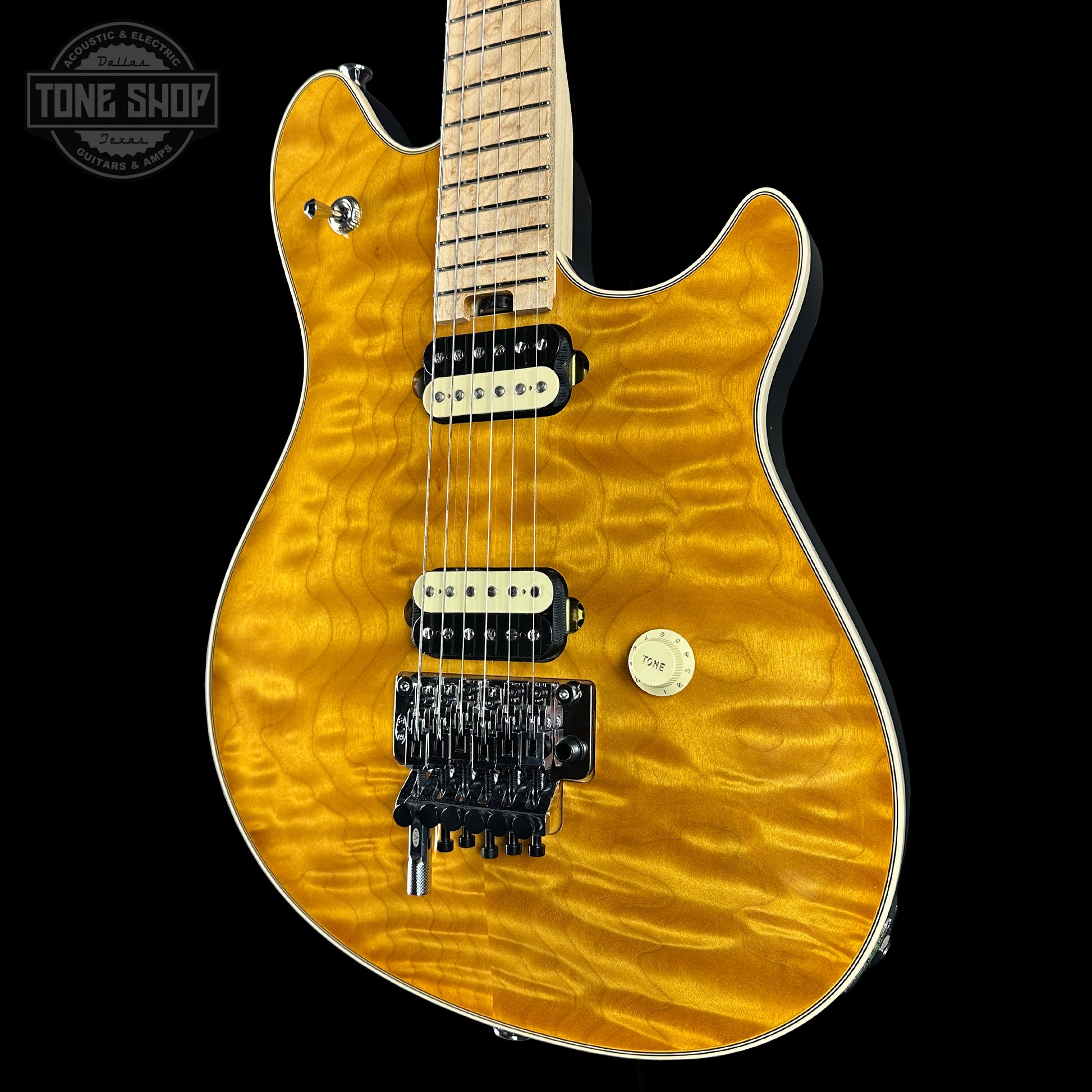 Electric guitar with a quilted maple top on a black background, featuring the Tone Shop logo.