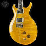 Yellow electric guitar with a black background, featuring the Tone Shop logo.