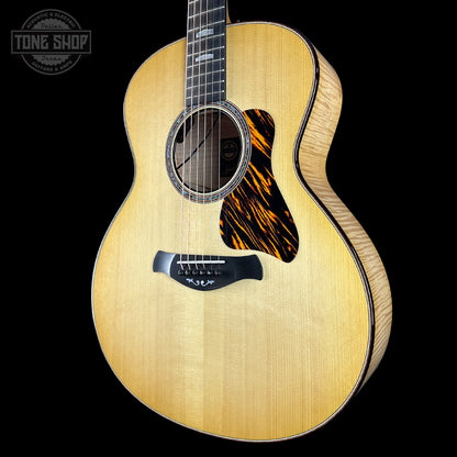 Acoustic guitar with a flame maple top on a black background, featuring the Tone Shop logo.