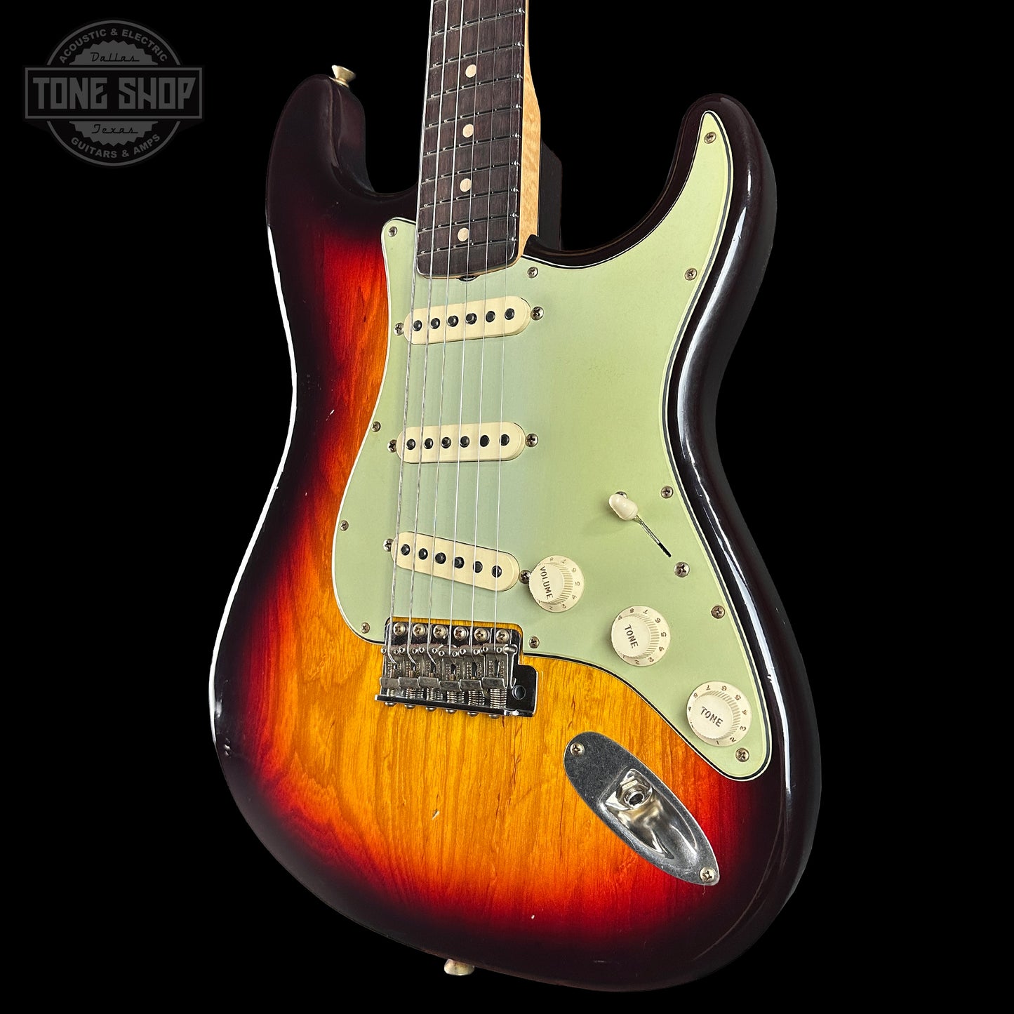 Electric guitar with sunburst finish on a black background, featuring the Tone Shop logo.