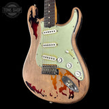 Distressed electric guitar with a unique design on a black background, featuring the Tone Shop logo.