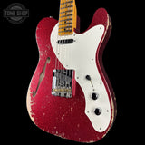 Red electric guitar with white pickguard on a black background, featuring 'Tone Shop' logo.
