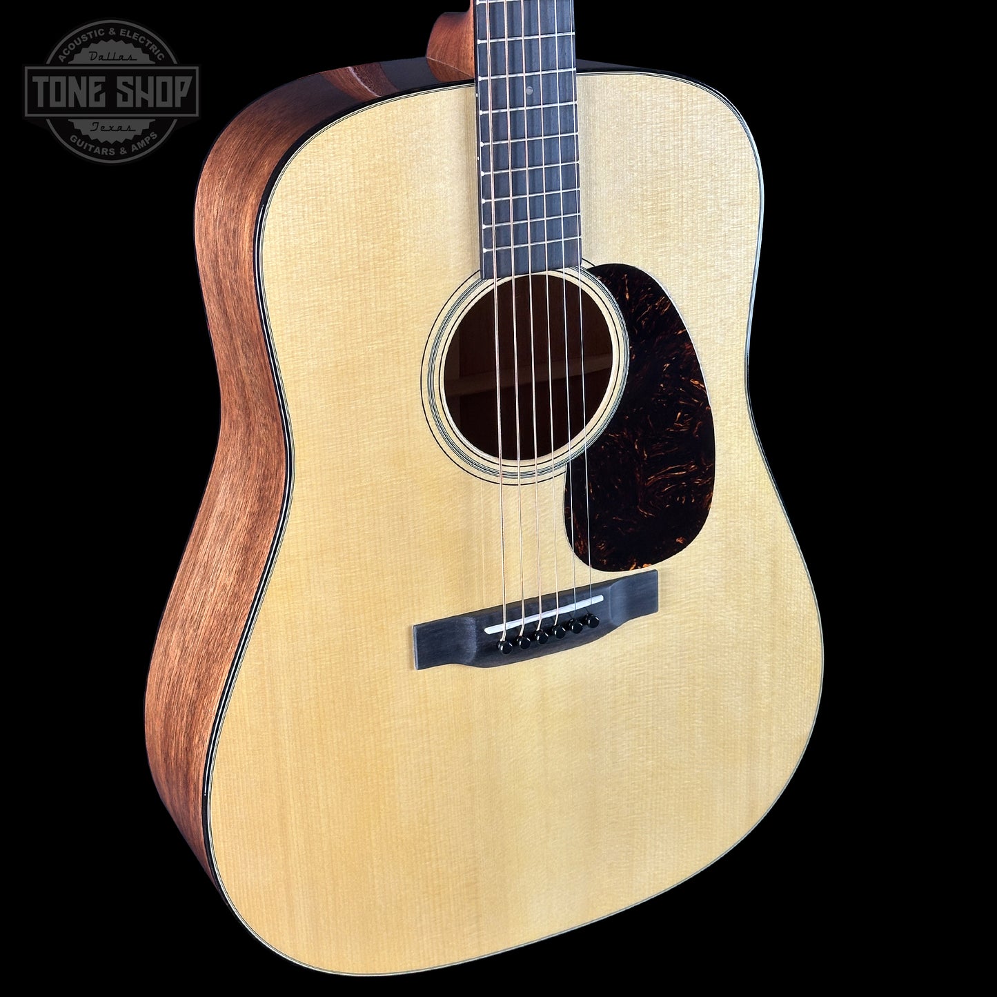 Acoustic guitar with a visible brand logo on a black background