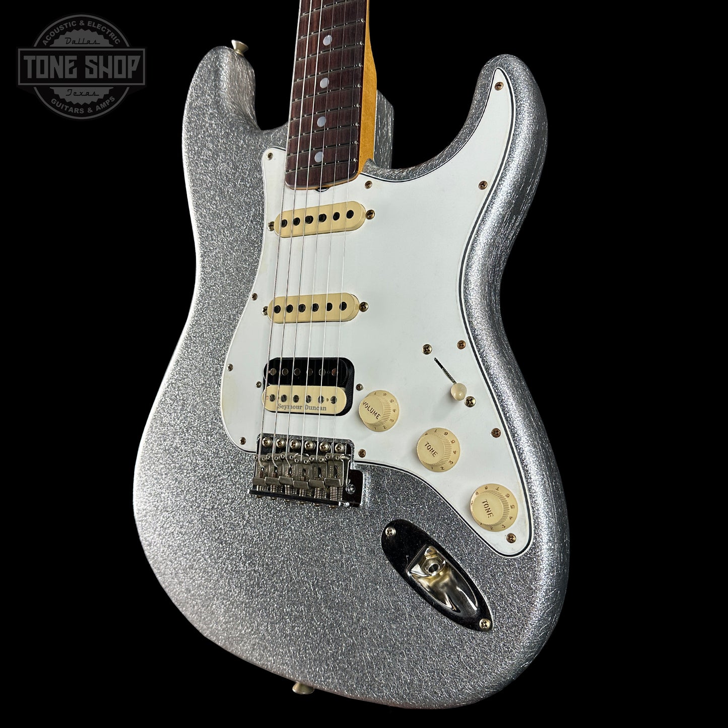 Silver glitter electric guitar on a black background with 'Tone Shop' logo.