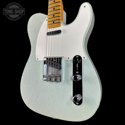 White electric guitar with a black pickguard on a black background, featuring 'Tone Shop' branding.