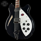 Black and white electric guitar with visible brand logo on a black background