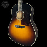 Acoustic guitar with a sunburst finish on a black background, featuring the Tone Shop logo.