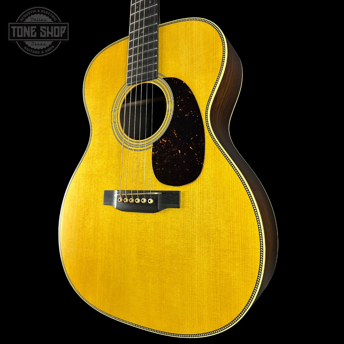 Acoustic guitar with a visible brand logo on a black background