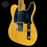 Electric guitar with a blonde finish on a black background, featuring the Tone Shop logo.