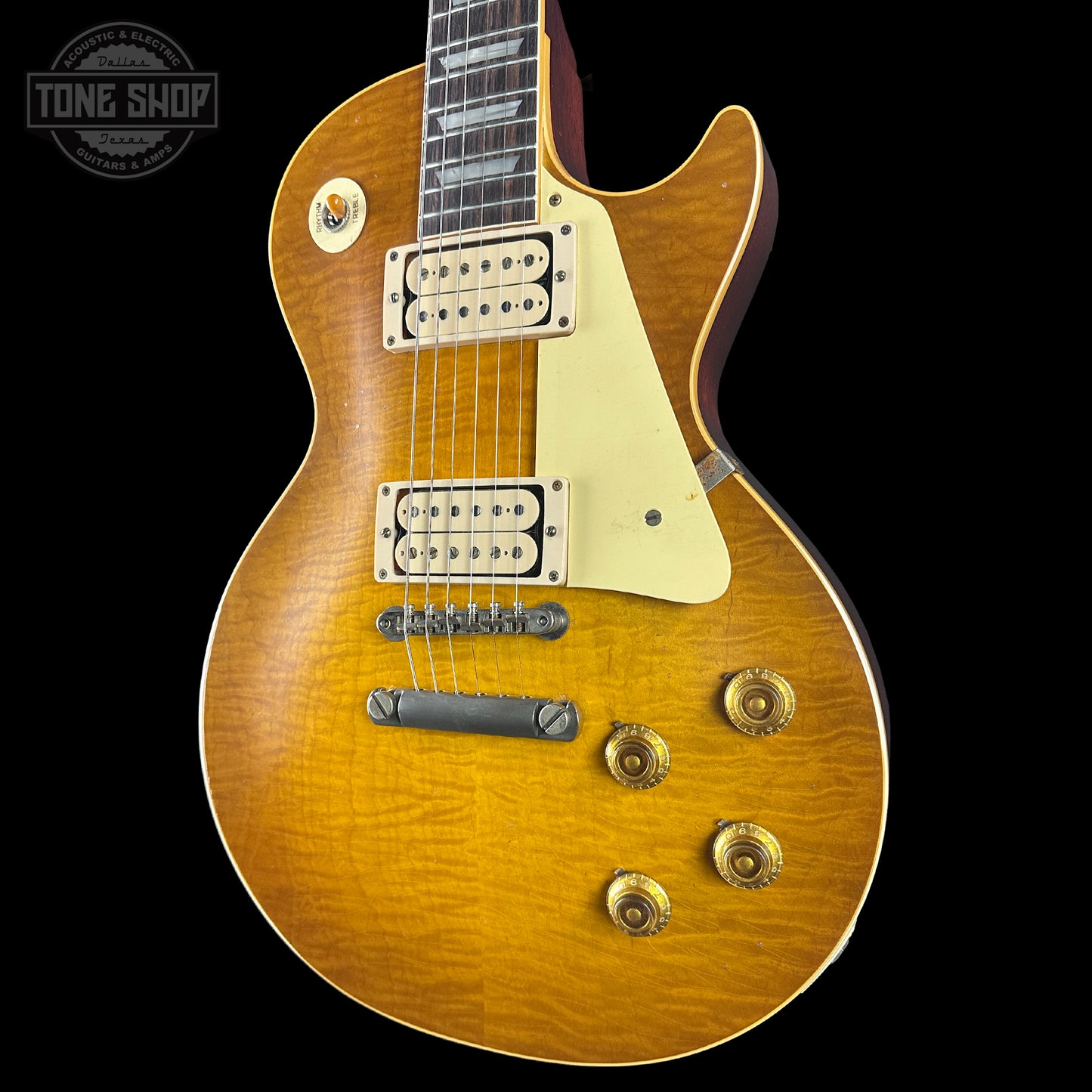 Electric guitar with a sunburst finish on a black background, featuring the Tone Shop logo.