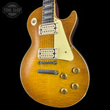 Electric guitar with a sunburst finish on a black background, featuring the Tone Shop logo.