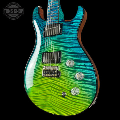 Electric guitar with a wavy green and blue finish on a black background, featuring the Tone Shop logo.