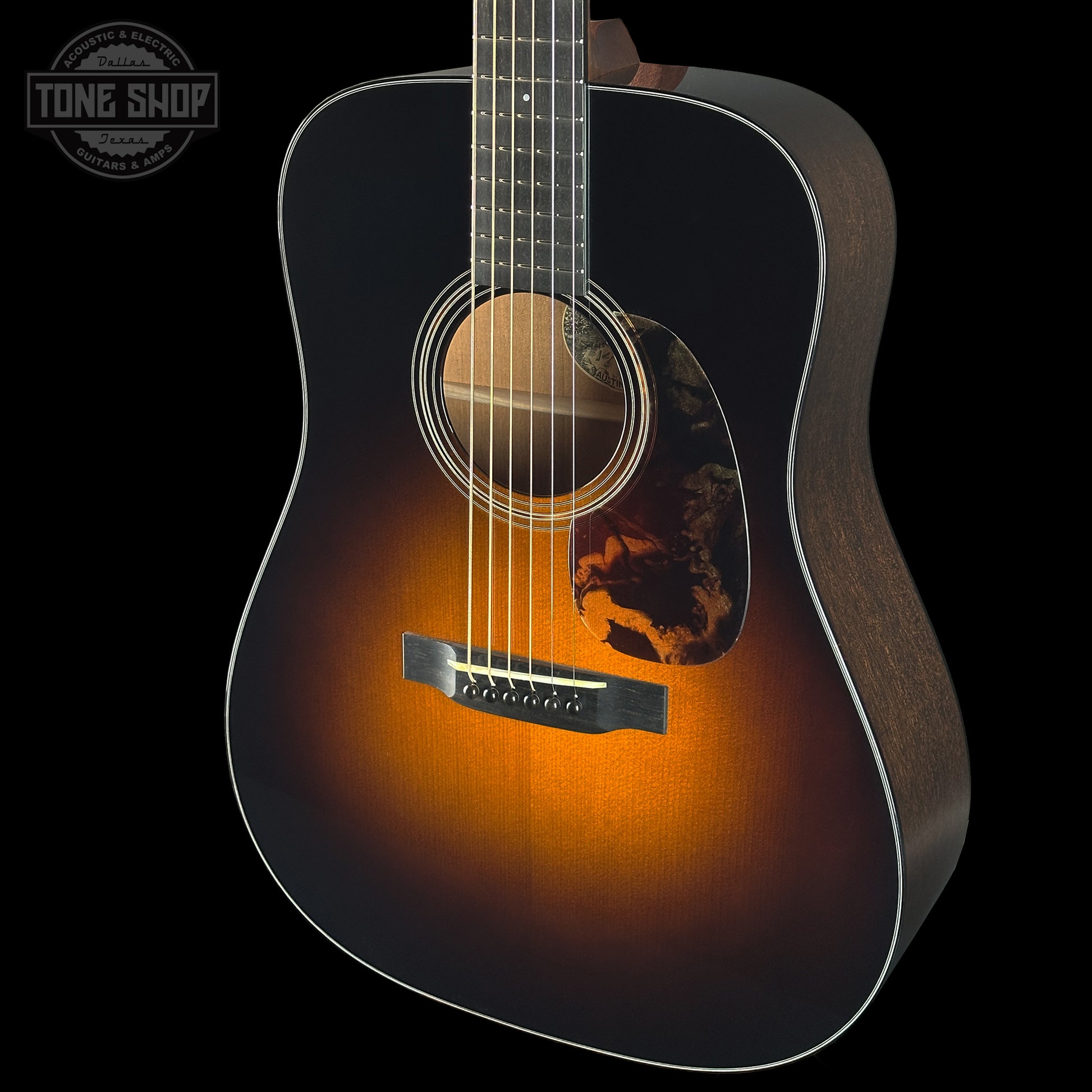 Acoustic guitar with a sunburst finish on a black background, featuring the Tone Shop logo.