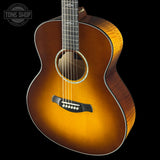 Acoustic guitar with a sunburst finish on a black background, featuring the Tone Shop logo.