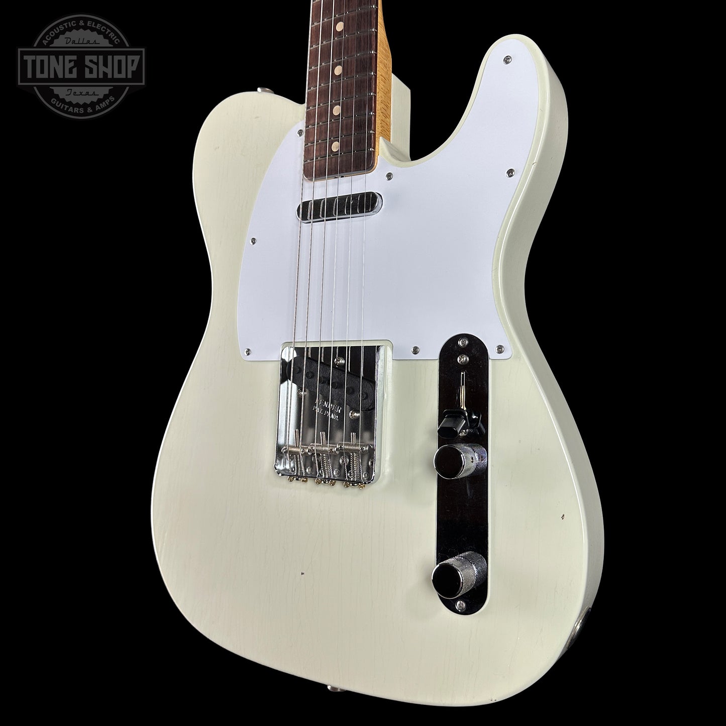 White electric guitar with a white pickguard on a black background, featuring 'Tone Shop' branding.