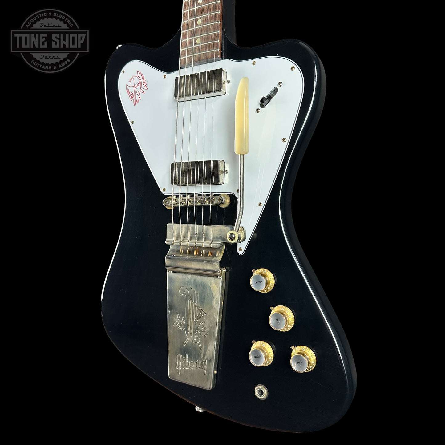 Black electric guitar with white pickguard on a black background, featuring the Gibson logo.