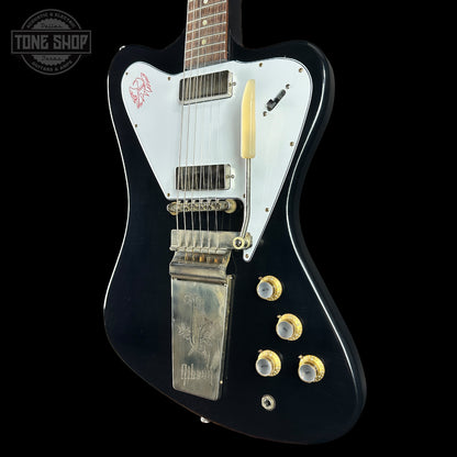 Black electric guitar with white pickguard on a black background, featuring the Gibson logo.