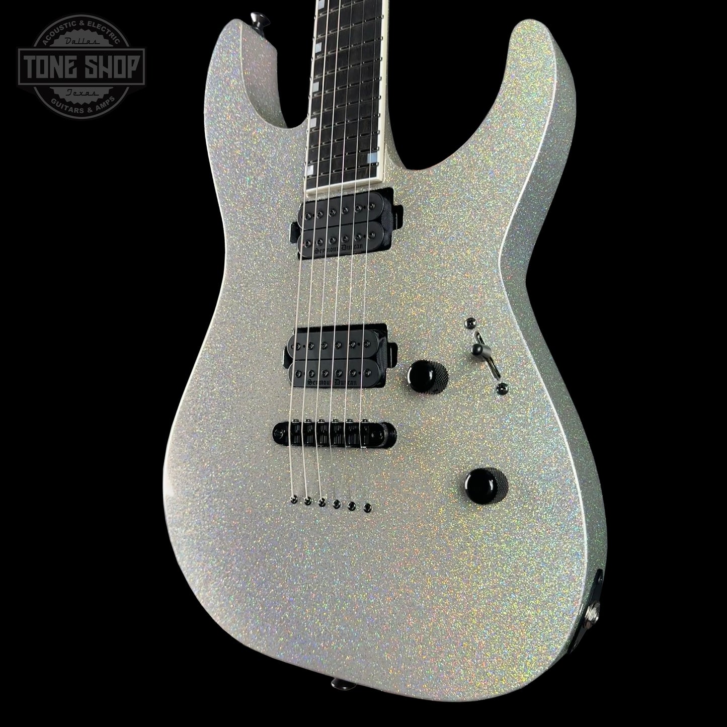 Silver electric guitar on a black background with 'Tone Shop' logo.