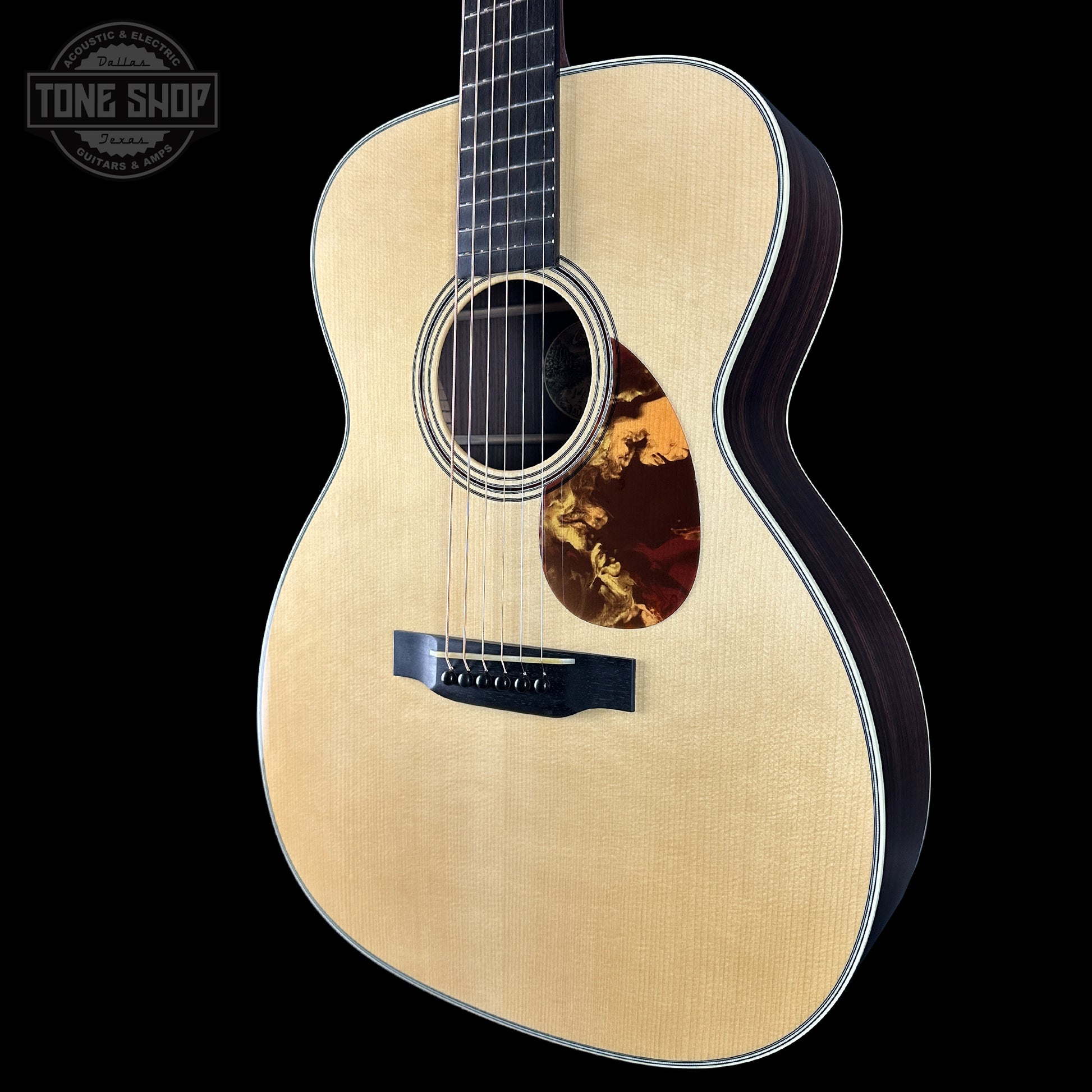 Acoustic guitar with a visible brand logo on a black background