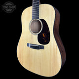 Acoustic guitar with a visible brand logo on a black background